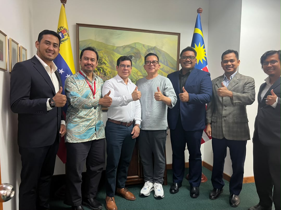 Group engagement photograph with Malaysia and Venezuela flags